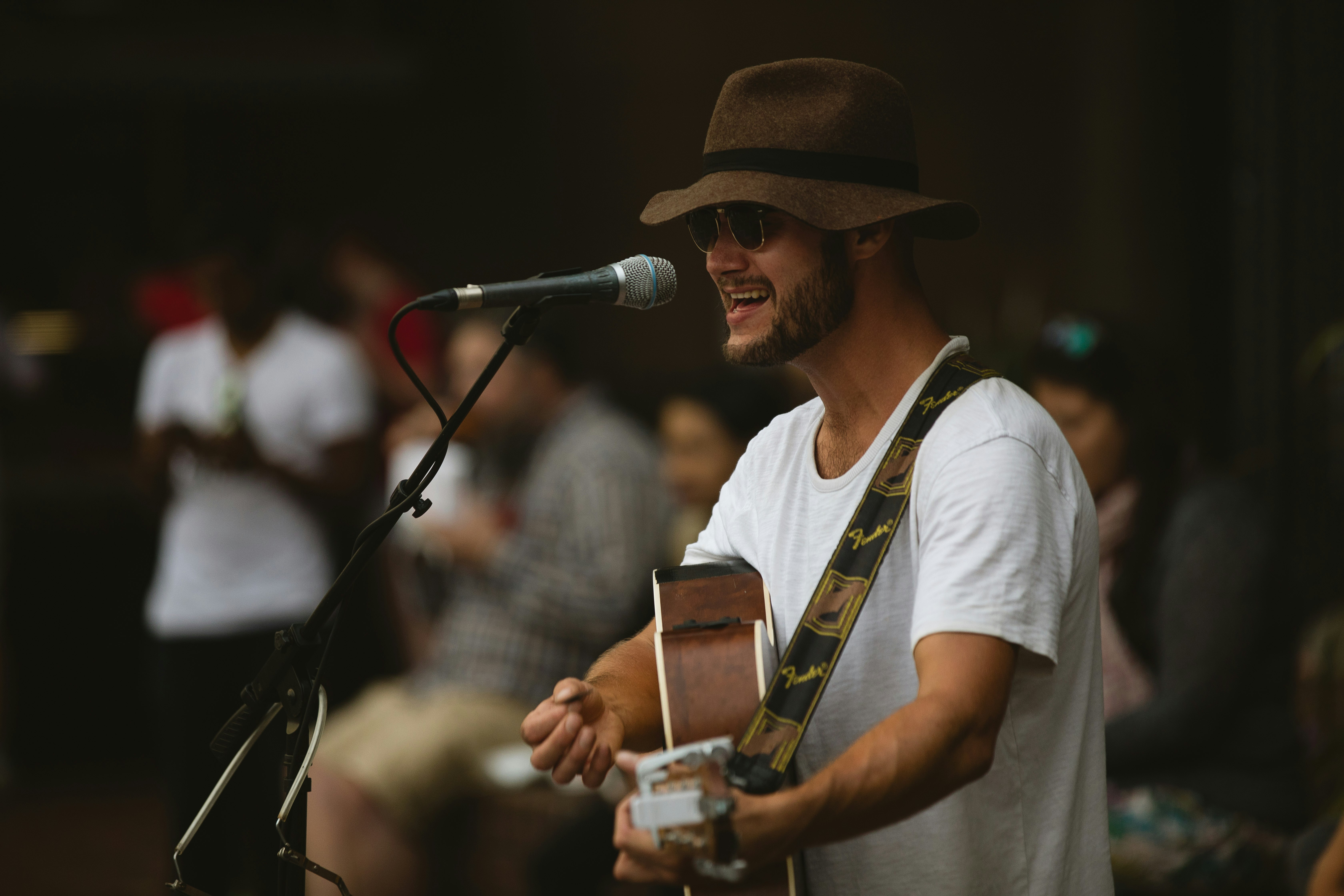 selective focus photography of man playing guitar and using microphone